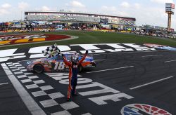 Kyle Busch salutes the fans at Charlotte Motor Speedway after winning the TECH-NET Auto Service 300 powered by CARQUEST, his fourth straight NASCAR national series victory. Credit: Streeter Lecka/Getty Images